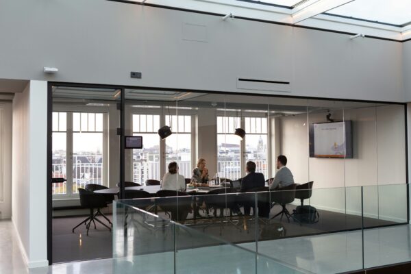 Illustrative business meeting in a glass-walled office
